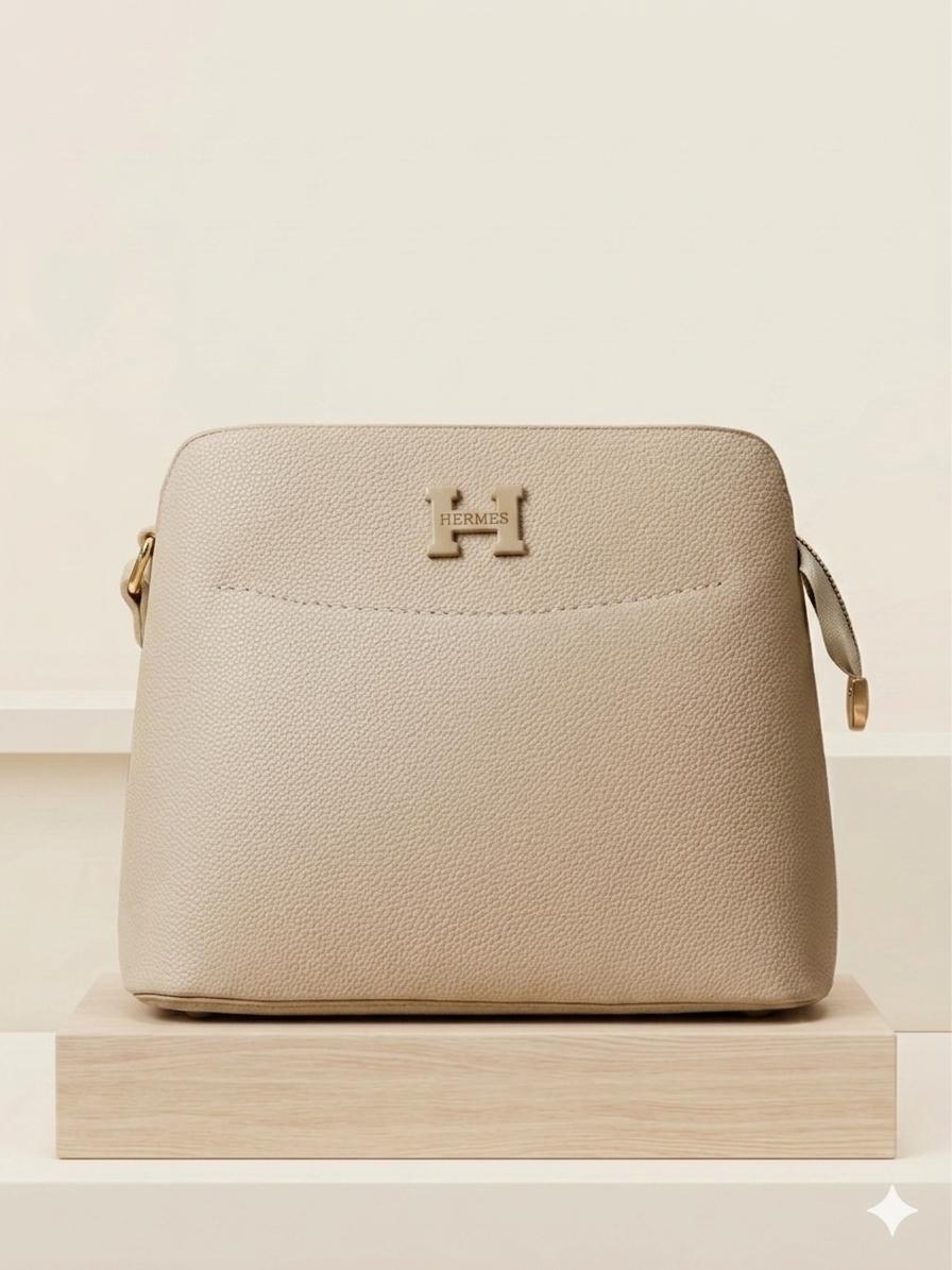 Beige handbag with gold accents on a beige background